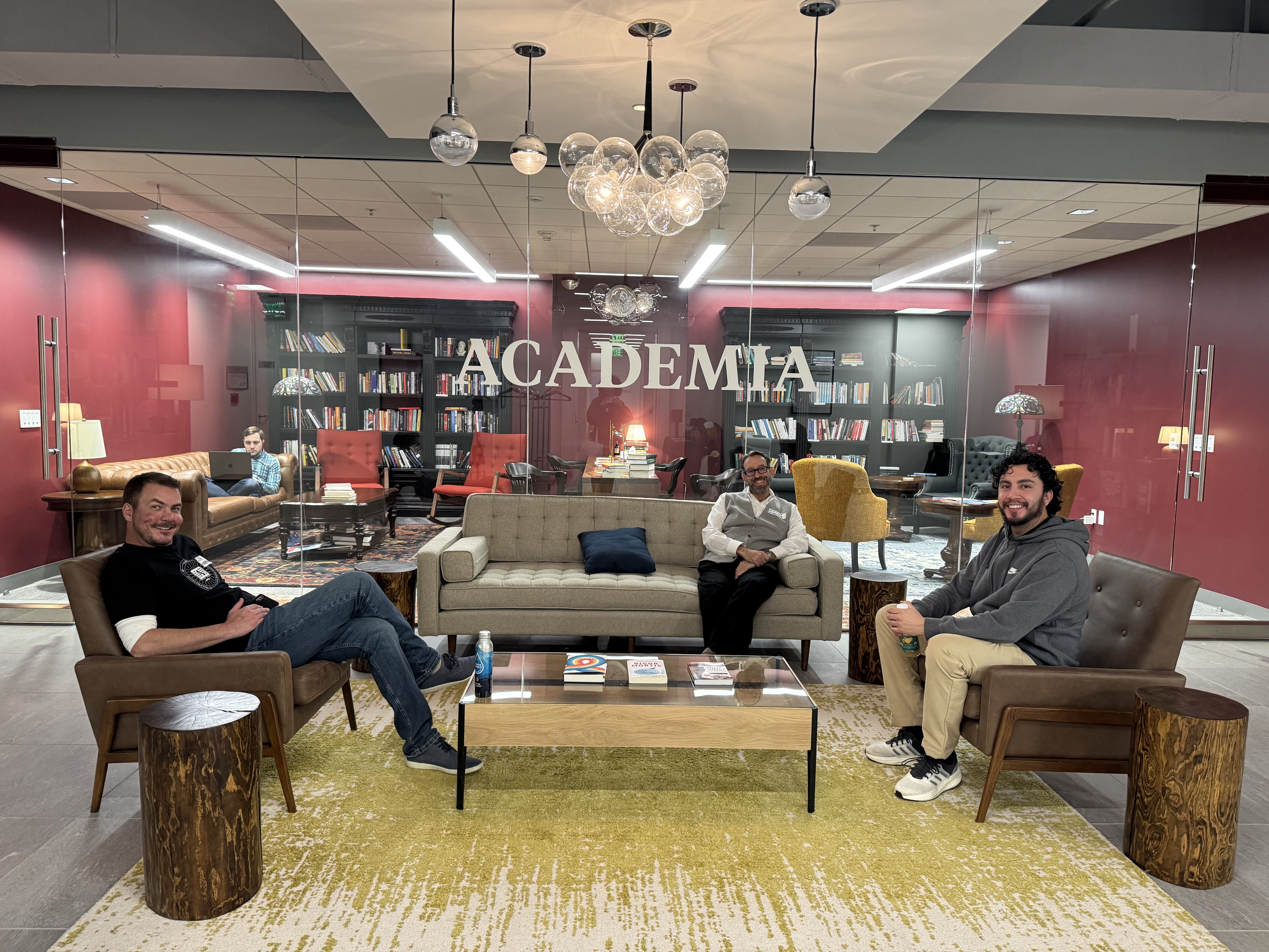 Academia.edu team members socializing in front of the office library. 