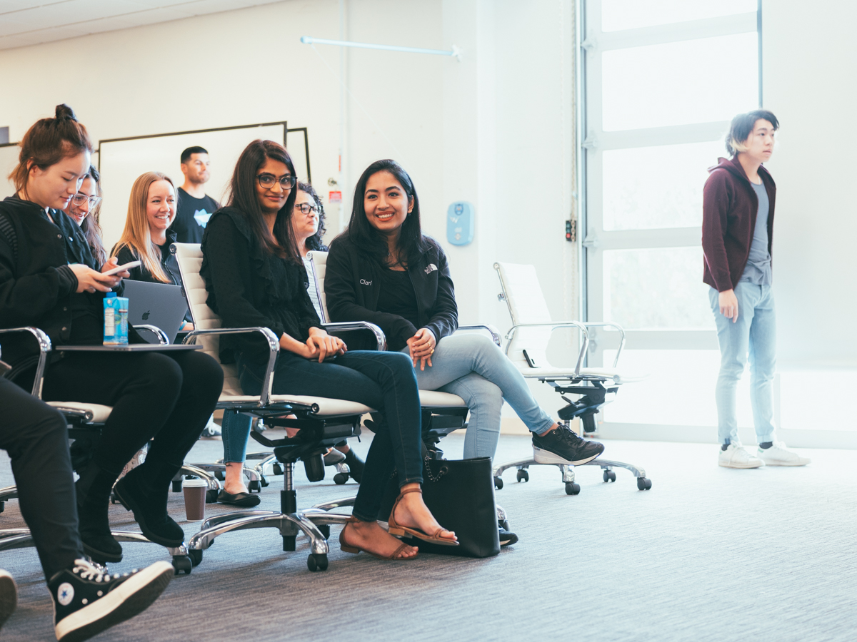  Employees at Clari sit in an audience waiting for a presentation to begin.