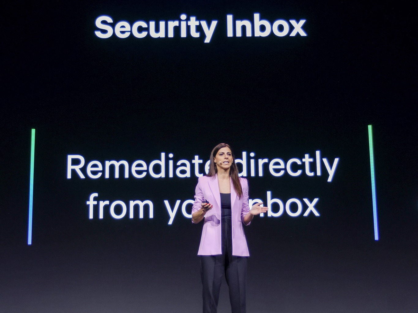 Datadog’s Director of Engineering Daniela da Cruz addresses the audience during a keynote speech. Behind her is text describing recent Datadog security products.