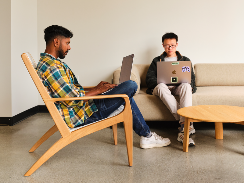 Two developers working in the Roblox platform on a laptop screen 