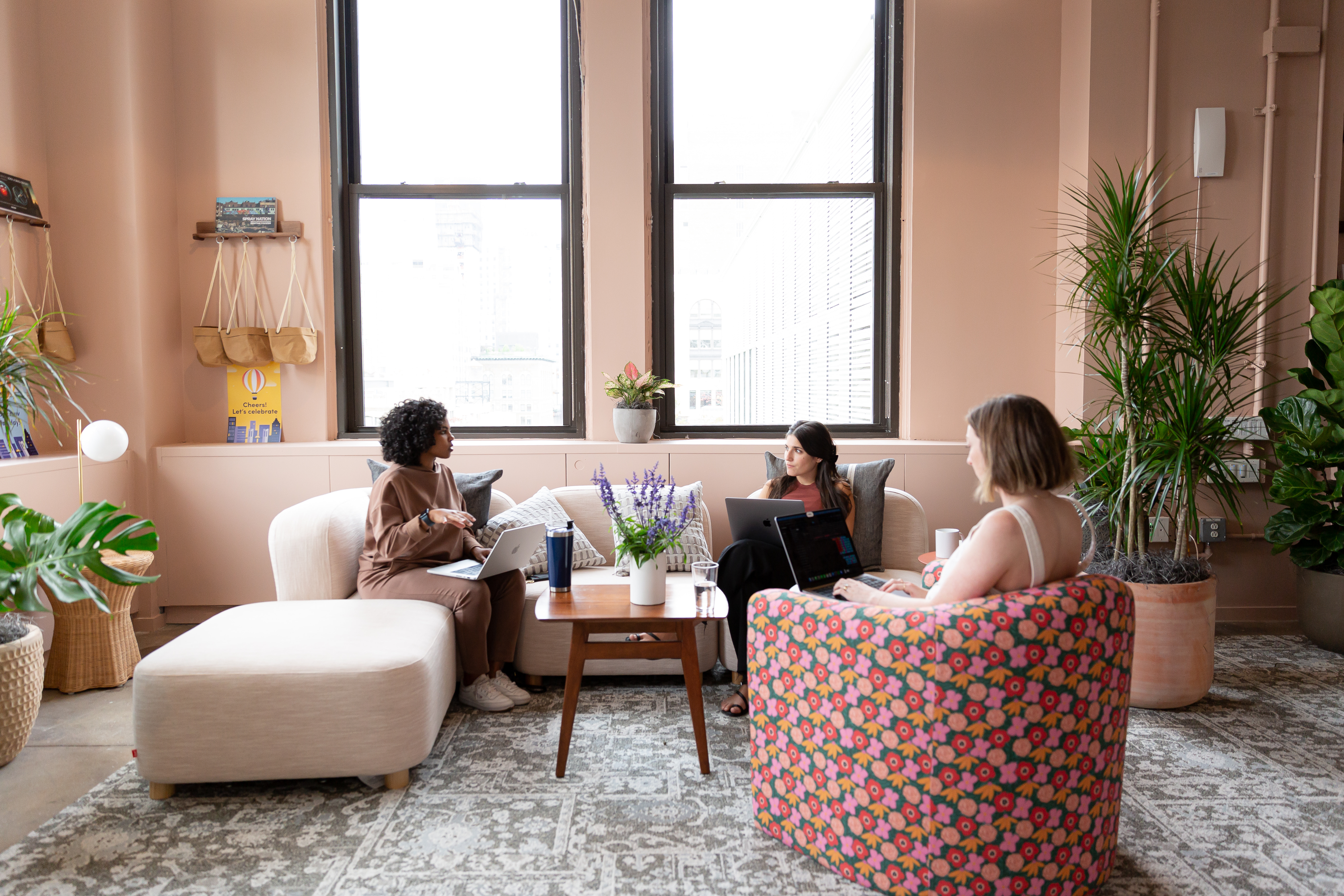  Employees seated on upholstered chairs and sofas, looking comfortable while working