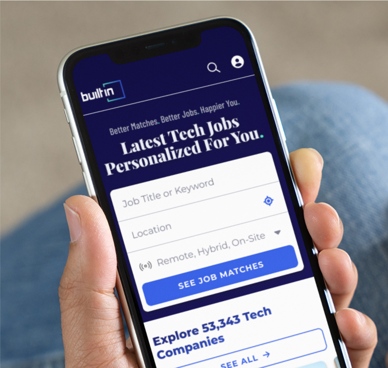 Hand holding mobile phone, on the screen is the Built In site, reading “Latest Tech Jobs Personalized for You.” 